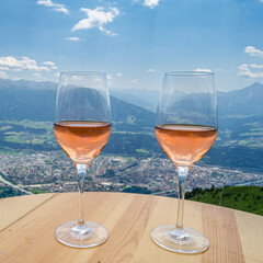 Two glasses of Austrian wine on a terrace with Alpine landscape in the background