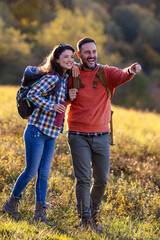 Couple standing in meadow in evening after hiking