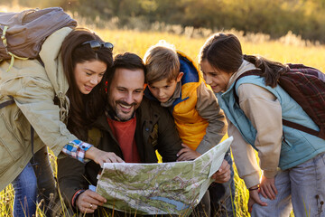 Family reading a mapr in a grassy field