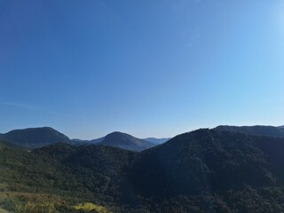 Panoramic View of Lush Green Mountains Under Clear Blue Sky