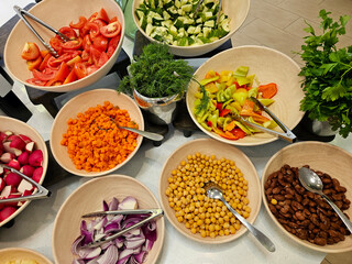 Buffet bar filled with fresh vegetables and garnishes ready for customers to make their salads