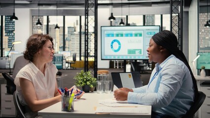 New hire sharing a handshake and receiving ID security pass from HR manager in onboarding meeting, confirming the approved employment process. New beginning for business job. Camera A.