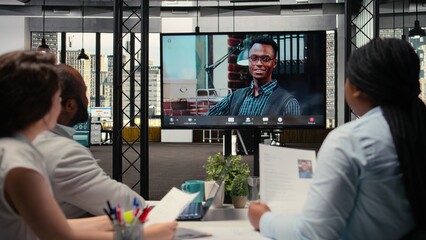 Recruiters conducting an online video interview with a candidate to evaluate employment history,...