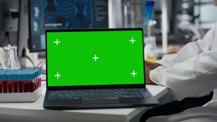 Senior scientist using green screen laptop software in laboratory, driving treatment discovery. Asian using bioinformatics application on mockup notebook in sterile lab, camera B - Powered by Adobe