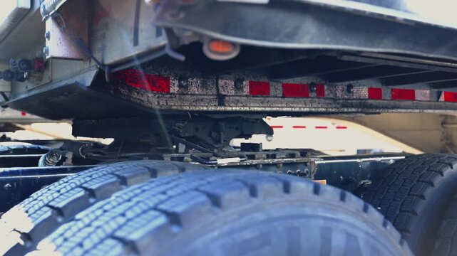 Truck is slowly unhooking the trailer on the parking lot. Slow motion. bottom view