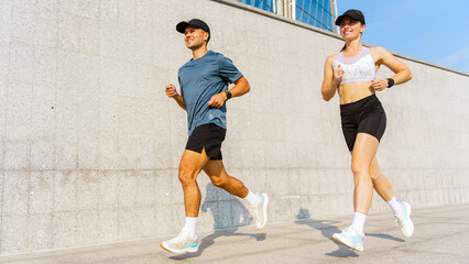Fototapeta premium Marathon training session in an urban setting with runners staying fit together