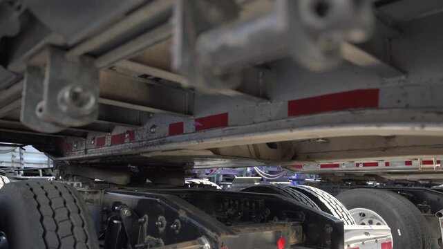 Truck is slowly hooking up the trailer on the parking lot. Slow motion. bottom view