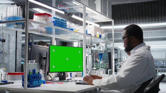 Lab worker using isolated screen computer for DNA data analysis, supporting clinical diagnostics research. African american man studying genomics for human health study using mockup PC, camera A