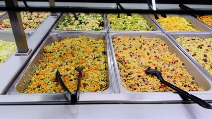 Variety of dishes ready to eat in the grocery store neatly displayed in trays on shelves. Close up