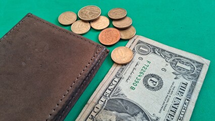 Wallet with Dollar Bill and Coins on Green Background