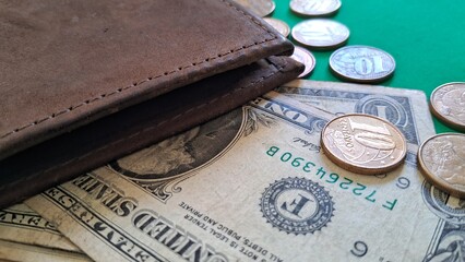 Wallet with Dollar Bill and Coins on Green Background
