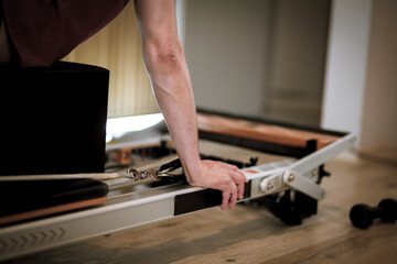 Engaging in a balanced workout on reformer pilates machines focusing on core strength and flexibility at a fitness studio