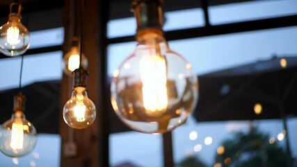 Warm Edison Bulbs Glow in Cozy Cafe Ambiance Against Blurry Outdoor Evening View - Powered by Adobe