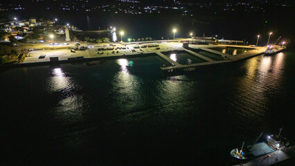 The atmosphere of Waingapu's Old Town to the Seaport seen from the air with a drone at night