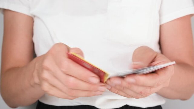 Close up of a woman sorting through plastic cards in her hands, searching for one. Concept of shopping, finance, banking, or personal organization
