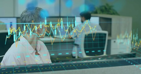 Woman wearing pink button-down shirt analyzing holographic data at office desk, with dual monitors