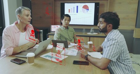 Analyzing business professionals reviewing malware alerts on charts and devices in conference room