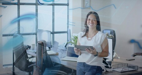 Smiling businesswoman wearing white blouse holding tablet in office, with digital overlays