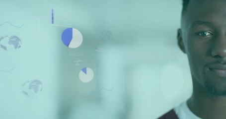 Facing camera man wearing maroon shirt in office, pie charts, line graphs, globe icons, copy space