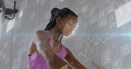 Leaning woman in pink tank top on exercise bike in studio with wall-mounted fan, digital overlay