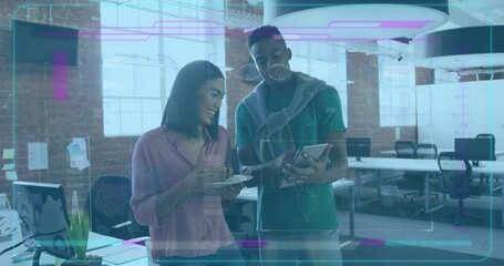 Reviewing tablet two professionals in casual clothes in loft office with coffee cup and succulent