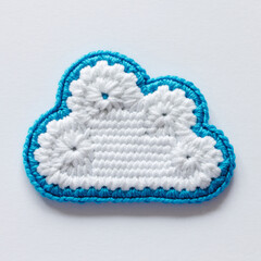Crocheted Cloud Applique with Blue Edging on White Background