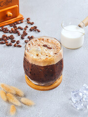 Iced Mocha Coffee with Cream Foam in Glass – Refreshing Cold Brew Drink on Gray Table