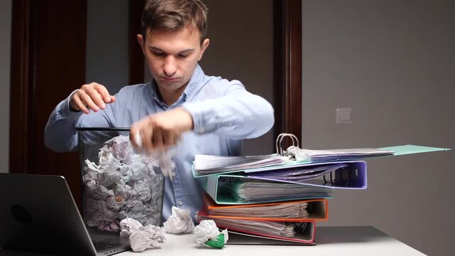 Office worker experiencing burnout throwing crumbled paper into bin