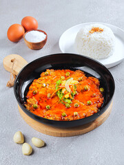 Indonesian Spicy Omelette with Red Sauce and Steamed Rice on Black Plate – Traditional Asian Cuisine Food Photography