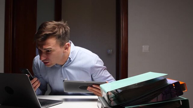Businessman multitasking with multiple devices experiencing information overload