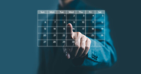 Businessman touching virtual digital calendar interface for scheduling and planning concept. Modern...