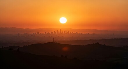 Fototapeta premium Vibrant urban skyline silhouette at sunrise with orange sky and hills in foreground panorama