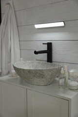 Portable LED light on wall over sink in bathroom