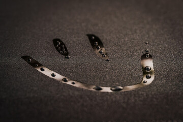 Happy face drawn in dew drops