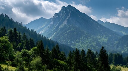 Majestic mountain peaks rise above verdant forested slopes under a dramatic sky