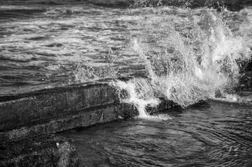 Closeup Background of Splash and Spray From a Wave Breaking on an Ocean Wall in Black and White.
