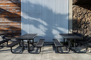 Twin Black and Metal Benches against a Silver and Brown Wall Background.