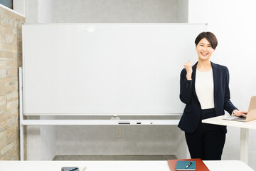 ホワイトボードの前に立つ女性のセミナー講師