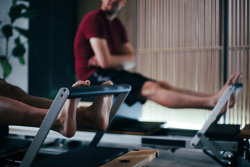Engaging in Pilates on Reformer Machines at a Modern Fitness Studio during Morning Workout Session