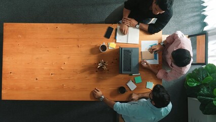 Top down aerial view of business team looking at financial graph while shaking hands for making...