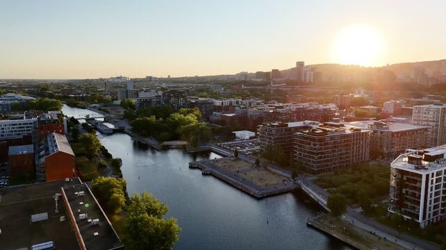 Aerial view of modern waterfront district with high-rise buildings and riverside paths, Montreal twilight skyline. g.