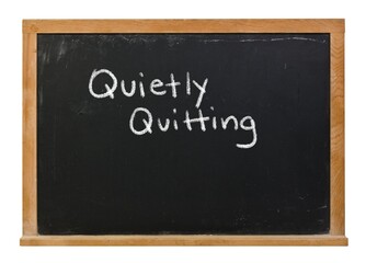 Quietly quitting written in white chalk on a black chalkboard isolated in a wooden frame