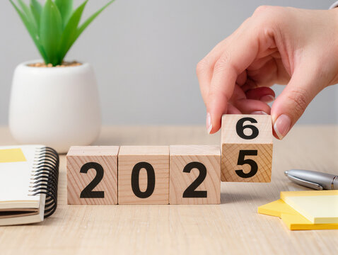 Hand changing wooden blocks from 2025 to 2026