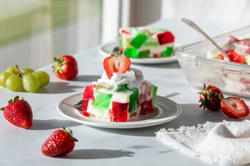 Servings of a homemade jelly dessert on a table next to a sunny window.