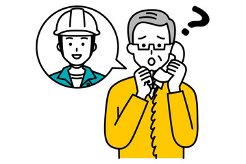 作業員に電話で相談する年配の男性