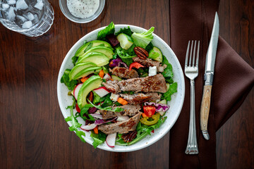 A top down view of a bowl of freshly made steak salad, ready for eating.