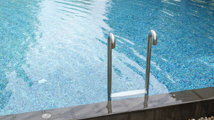 Swimming pool with stainless steel ladder stair and blue water