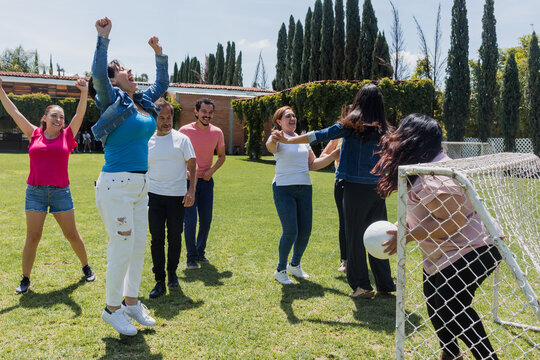 group of adult latin american friends playing football in public park in Mexico, team of hispanic senior people in outdoor activities