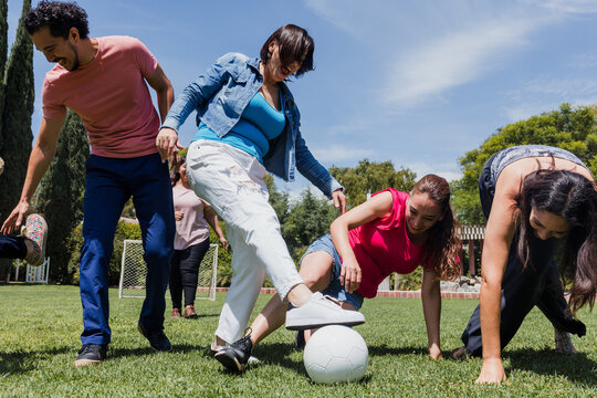 group of adult latin american friends playing football in public park in Mexico, team of hispanic senior people in outdoor activities