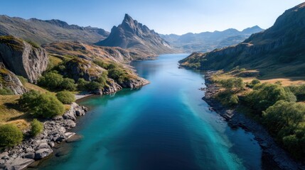 Naklejka premium Expansive Turquoise Mountain Lake Surrounded By Rugged Rocky Slopes Under A Clear Blue Sky With Lush Green Vegetation In The Foreground